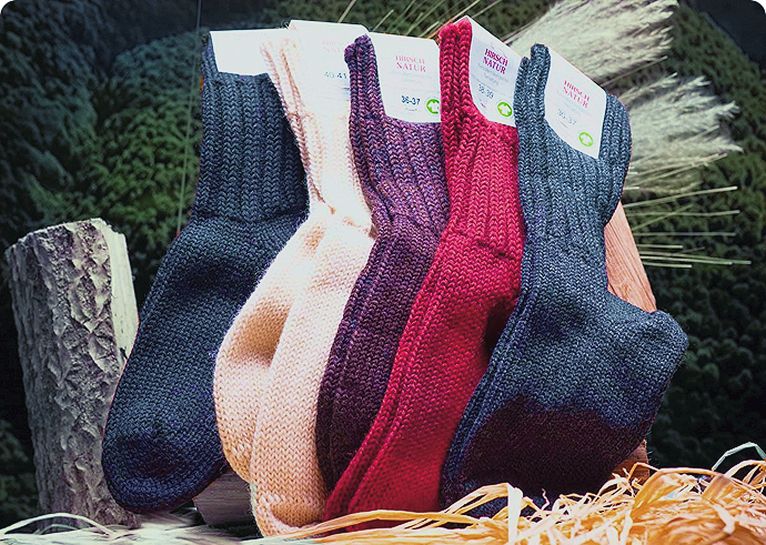 Fünf Paare dicke Hirsch Natur Socken in verschiedenen Farben auf einem Holzscheit